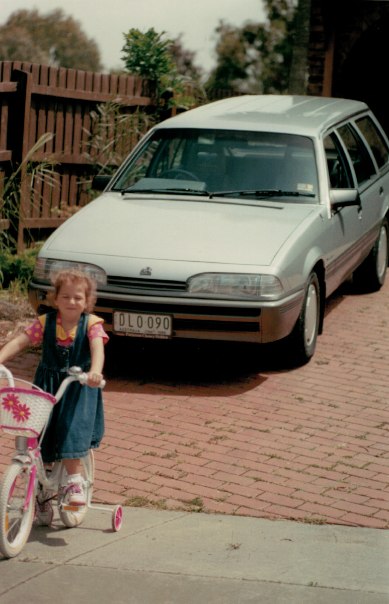 Holden VL Commodore parked on a driveway with a child on a bicycle in the foreground